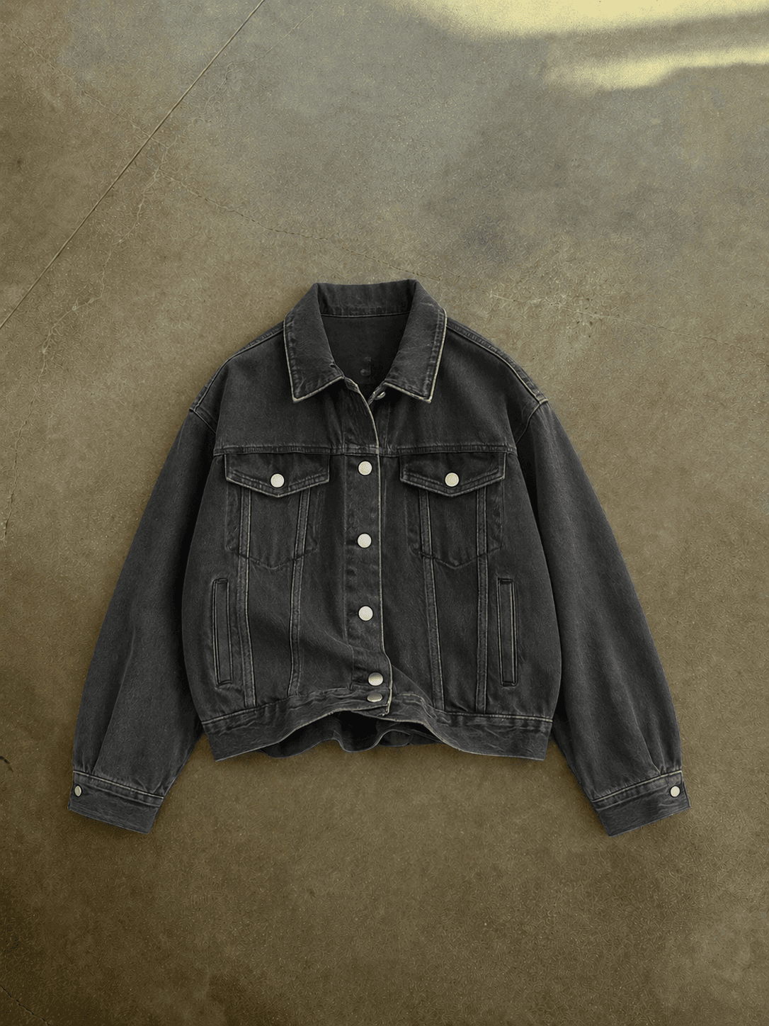 Black denim jacket on a brown textured background