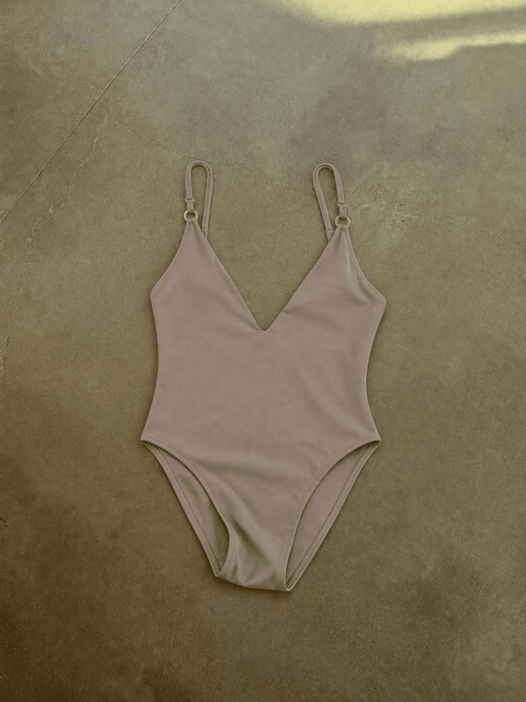 Beige swimsuit on a textured brown surface