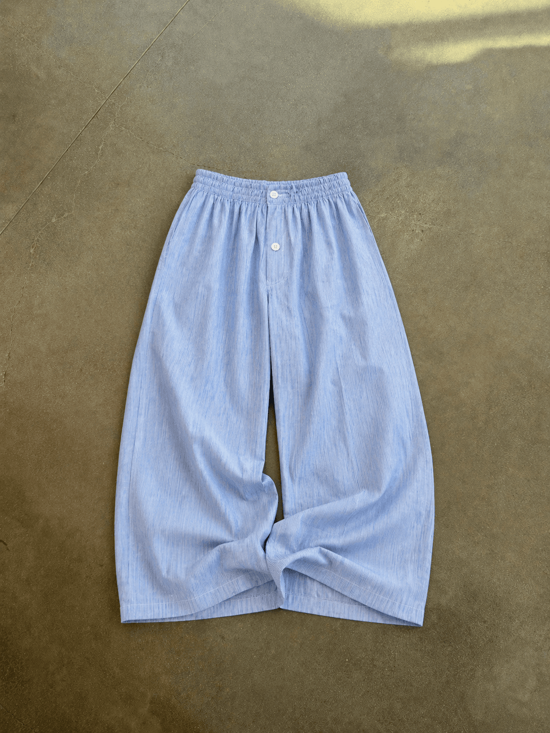 Light blue wide-leg pants on a brown surface
