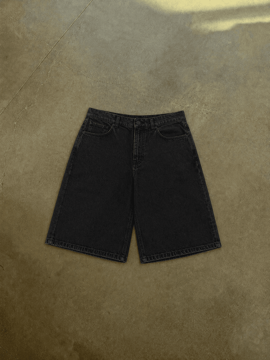 Black denim shorts on a brown surface
