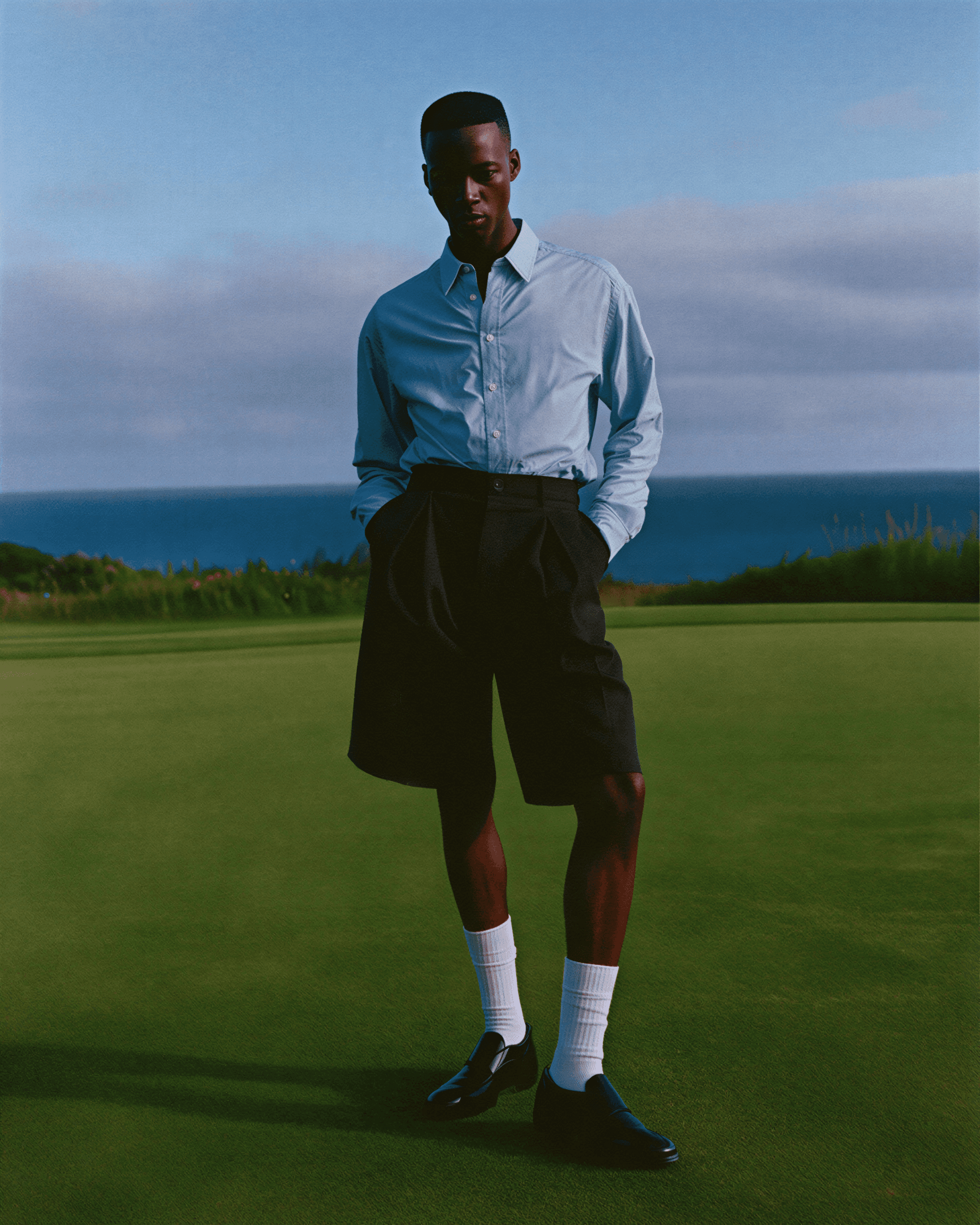 Man standing on a golf course with ocean in the background