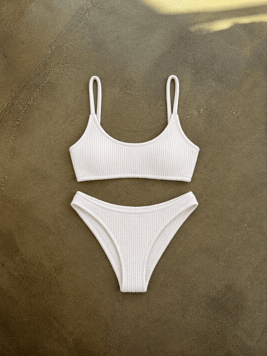 White ribbed bikini set on a textured brown surface