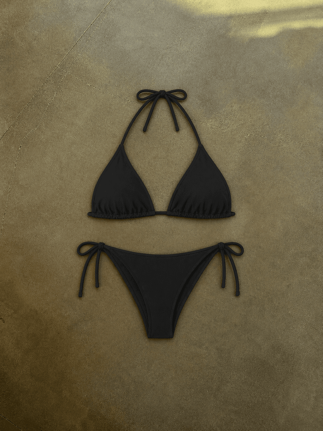 Black bikini set on a beige surface